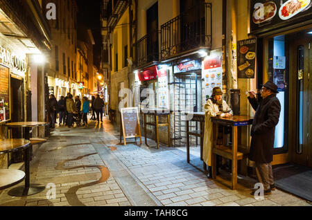 Logroño, La Rioja, Espagne - Février 14th, 2019 : un couple des boissons vin Rioja dans la Calle del Laurel Street au coeur de la vie nocturne dans le vieux Banque D'Images