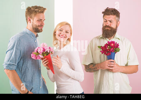 Girl smiling fait son choix. Girl populaires reçoivent beaucoup d'attention des hommes. Cœur brisé concept. Les hommes avec des fleurs bouquets concurrents essayer conquérir fille. Femme heureuse prend bouquet fleurs cadeau romantique. Banque D'Images