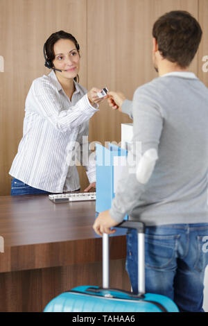 Réceptionniste femme carte clé donnant de chambre d'hôtel à client Banque D'Images