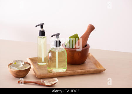 Bolw de l'aloès sur une planche à découper et gel douche bio en bouteille sur le plateau en bois Banque D'Images