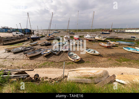 Un grand nombre de barques et bateaux disponibles assis sur la boue à Leigh on Sea, Essex, UK à marée basse. Météo variable avec des nuages menaçants Banque D'Images