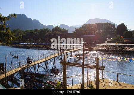 Bambou étroit pont sur la rivière au crépuscule de profonde soleil du soir - Vang Vieng, Laos Banque D'Images