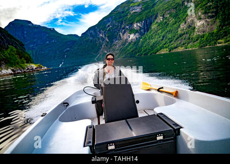 Femme au volant d'un bateau à moteur. Fjord de Geiranger, Belle Nature Norvège.vacances d'été. Fjord de Geiranger, Site du patrimoine mondial de l'UNESCO. Banque D'Images