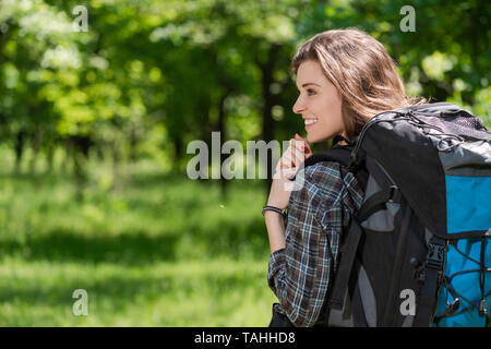 Vue arrière d'girl avec sac à dos, sur fond de forêt Banque D'Images