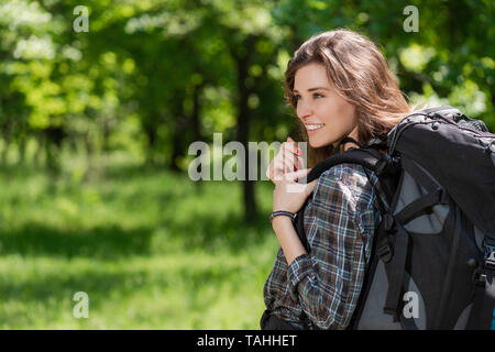 Vue arrière d'Femme avec sac à dos, sur fond de forêt Banque D'Images