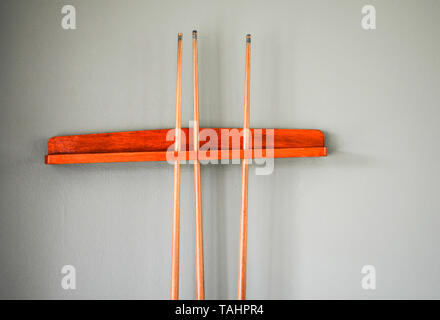 Billiard cue bâtonnets dans le réceptacle, sur le mur pour jouer en salle de snooker sports club - équipement pour jeu de billard Banque D'Images