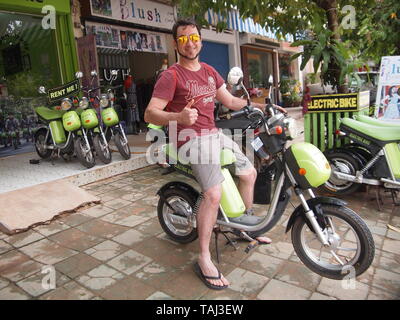 Client heureux up avec Green Eco Electric e-Bike Moto Vélo Scooter, sur une aventure Cambodge Siam Reap Banque D'Images