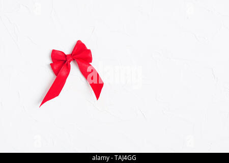 Red bow on white background. Copier l'espace. Des maquettes. Mise à plat. Vue d'en haut Banque D'Images