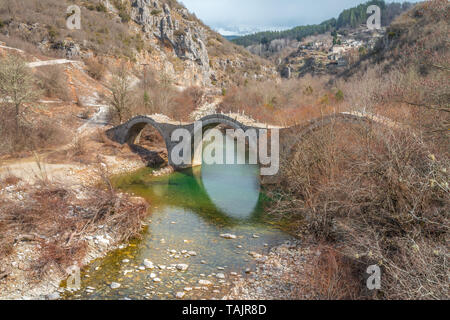 Arche triple pont de pierre de Kalogeriko Zagoria, dans la Grèce. Vieux pont de pierre à trois arches traversant une rivière avec de l'eau émeraude en Grèce les montagnes. Banque D'Images