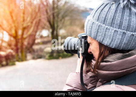 Femme photographe prendre des photos avec sa caméra en chiffres par une journée d'hiver en plein air Banque D'Images