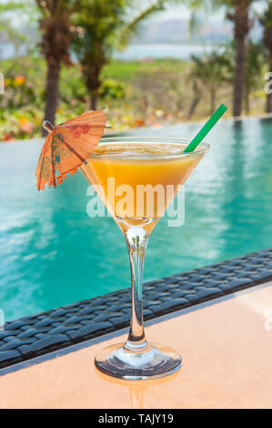 Daiquiri mangue sur une table en verre de la piscine en été Banque D'Images