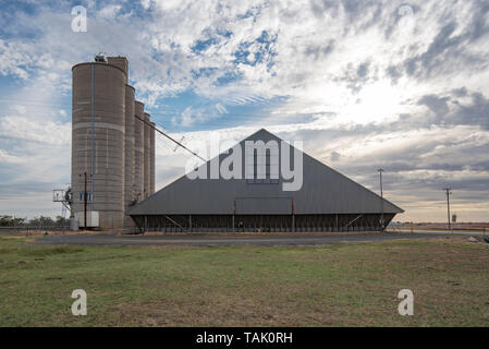 La fin de l'après-midi nuages sur les silos à grains et des soutes à côté de la ligne de chemin de fer dans la ville de Burren Junction dans le nord-ouest de la Nouvelle-Galles du Sud, Australie Banque D'Images