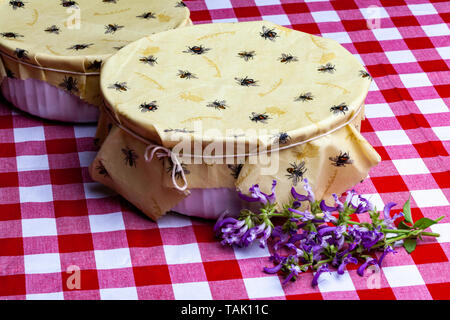 Cire faite maison avec enveloppe contenant Cute Bee Design sur une nappe à carreaux rouge et blanc avec le Chinois (Danshen) Sage en fleur Banque D'Images