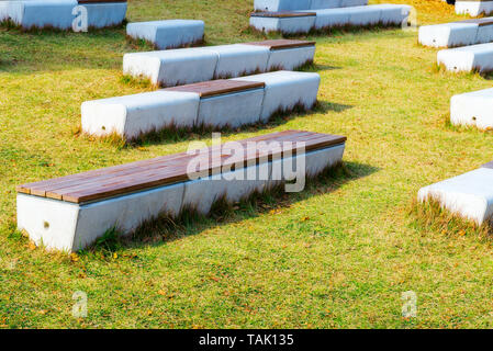 Avec du béton banc haut dans le parc on Green grass Banque D'Images