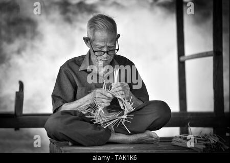 La vie Asie vieux grand-père oncle travaillant dans accueil / homme sérieux âgés vivant dans la campagne de la vie des populations rurales dans la Thaïlande bambou tissage bask Banque D'Images