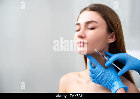 Sourire du levage et augmentation des lèvres. Médecin coiffeur beauté faisant mains procédure à visage de femme avec une seringue. La bouche de la jeune femme avec countouring Banque D'Images