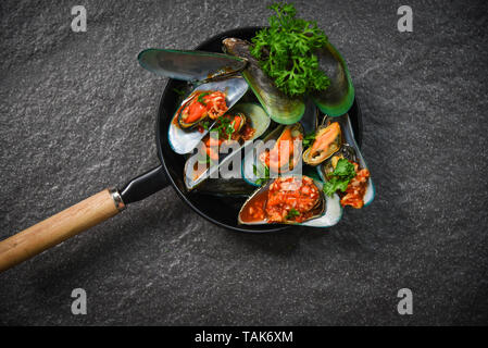 La cuisson des moules fruits de mer crustacés avec plaque de moule zébrée verte ocean shell dîner gastronomique, cuit avec des herbes et épices pour fruits de mer sauce chili vue supérieure Banque D'Images