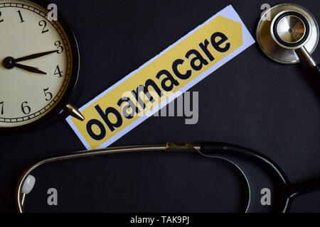 L'Obamacare sur du papier d'impression avec les concept d'Inspiration. réveil, noir stéthoscope. Banque D'Images