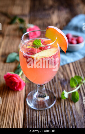 Pêche framboise boisson rafraîchissant mimosa sur un fond de bois Banque D'Images