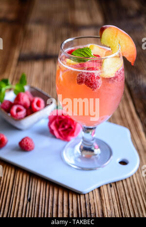 Pêche framboise boisson rafraîchissant mimosa sur un fond de bois Banque D'Images