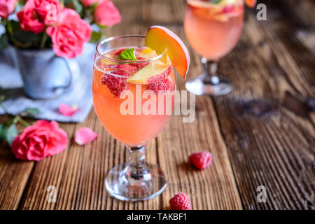 Pêche framboise boisson rafraîchissant mimosa sur un fond de bois Banque D'Images