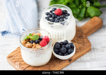 Le yogourt grec surmontée de granola, bleuets, framboises dans un pot Banque D'Images