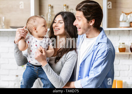 Les jeunes parents de jouer avec leur bébé adorable fils dans la cuisine Banque D'Images