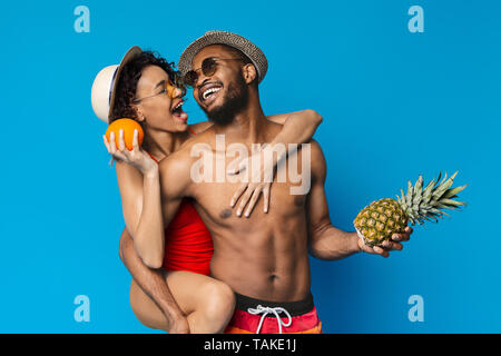 African American couple piggybacking et manger des fruits Banque D'Images