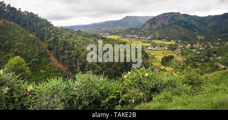 Paysage typique de Madagascar à Mandraka région. Collines couvertes de feuilles vertes, de petits villages dans la distance, temps couvert sur Banque D'Images