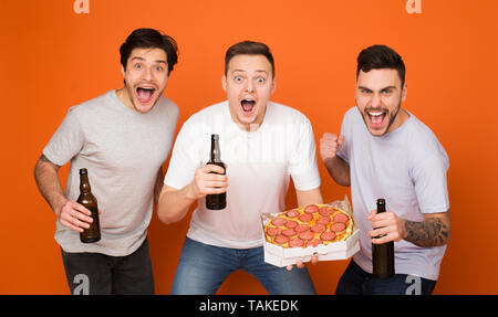 Heureux les Amis de boire une bière et manger des pizzas, fond orange Banque D'Images