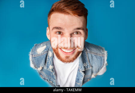 Au-dessus du portrait de funny guy redhaired millénaire, smiling at camera vers le haut Banque D'Images