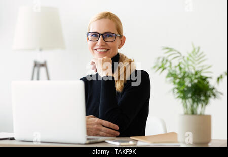 Mature Businesswoman Working On Laptop At Home Office Banque D'Images