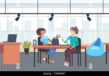 Couple businesswomen collègues discutez lors de pause café mix race business women sitting at workplace communication concept bureau moderne Illustration de Vecteur