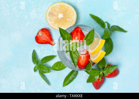 Basilic fraise dans un verre de limonade, de fraises fraîches, basilic sur fond bleu Banque D'Images