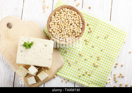 Mise à plat sur le soja caillé le tofu sur une planche à découper avec bol de haricots de côté. Substitut laitier substitut de fromage Banque D'Images