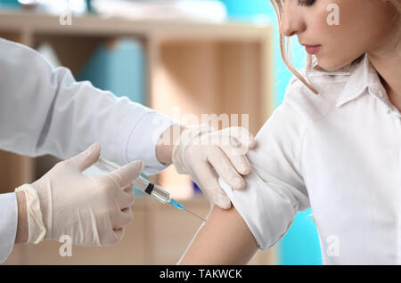 Femme médecin vaccinant contre la grippe en clinique Banque D'Images