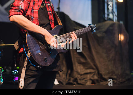 Guitare électrique dans les mains d'un rocker. Un homme joue de la guitare à un concert de rock. Banque D'Images