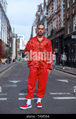 Un jeune homme habillé en rouge, Soho, Londres, Angleterre, Royaume-Uni. Banque D'Images