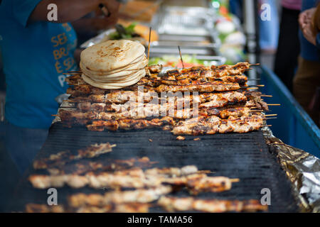 Brochettes de kébab au poulet et pain pita cuisant sur un grill dans un marché de rue à New York City, États-Unis. Banque D'Images