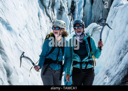 Deux femmes devant une grande crevasse avec piolets. Les glaciéristes être heureux à l'extérieur sur un glacier en Alaska. Banque D'Images