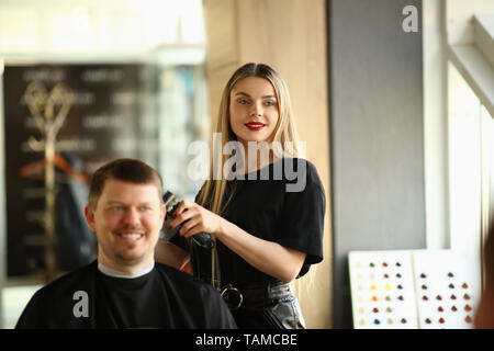 Jeune fille Hairstylist Shave Male Client Banque D'Images