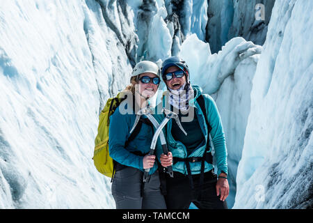 Deux femmes avec des piolets croisés devant la grande crevasse. Ils guider les clients vers le Glacier Matanuska pendant l'été. Banque D'Images