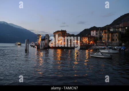 Varenna/Italie- 6 avril 2014 : Belle vue panoramique sur le lac de Côme avec un navire à passagers s'éloigner du port de Varenna au coucher du soleil au printemps. Banque D'Images