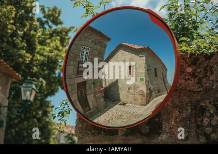 Maisons anciennes sur la place pavée, reflétée dans un miroir de rue à Linhares da Beira. Un hameau médiéval à l'architecture unique dans l'est du Portugal. Banque D'Images