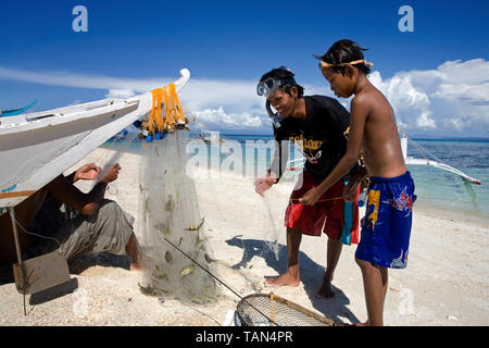 Pêcheur prend la capture dans la filet de pêche, Bounty beach, Malapascua Island, Cebu, Philippines Banque D'Images