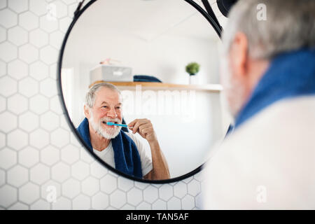 A senior man se brosser les dents dans la salle de bains à l'intérieur à la maison. Copier l'espace. Banque D'Images