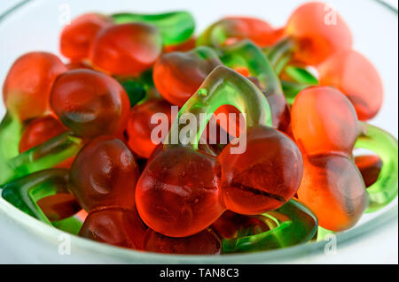 Bol en verre coloré de bonbons gommeux sur fond blanc Banque D'Images