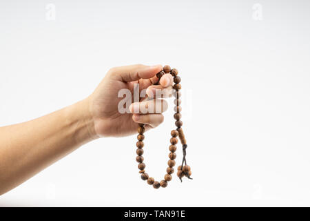 Main tenant un chapelet musulman Tasbih ou sur fond blanc. L'espace de copie et selective focus Banque D'Images