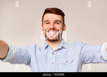 Beau jeune homme tenir l'appareil photo et faire selfies Banque D'Images