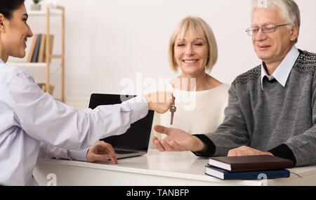 Donner de l'agent immobilier Mature couple clé de la nouvelle maison Banque D'Images